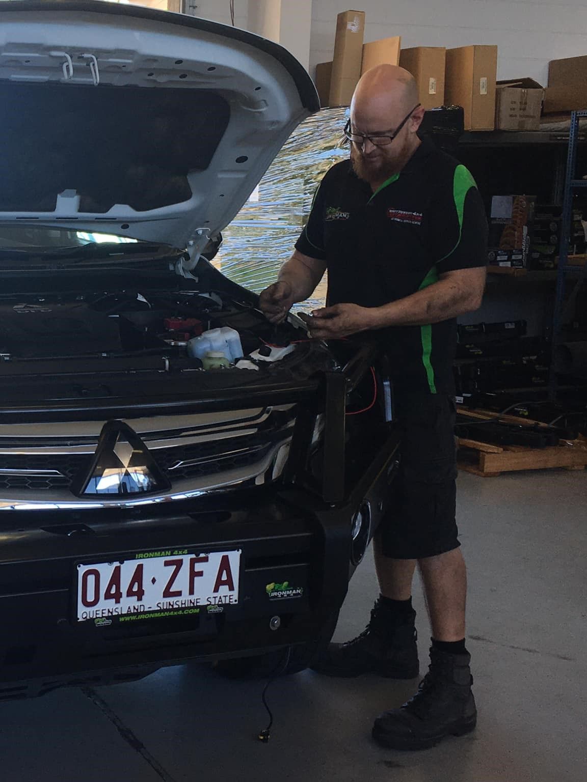 A Man is Working on a Car With the Hood Open in a Garage — Whitsunday 4x4 & Automotive In Proserpine, QLD