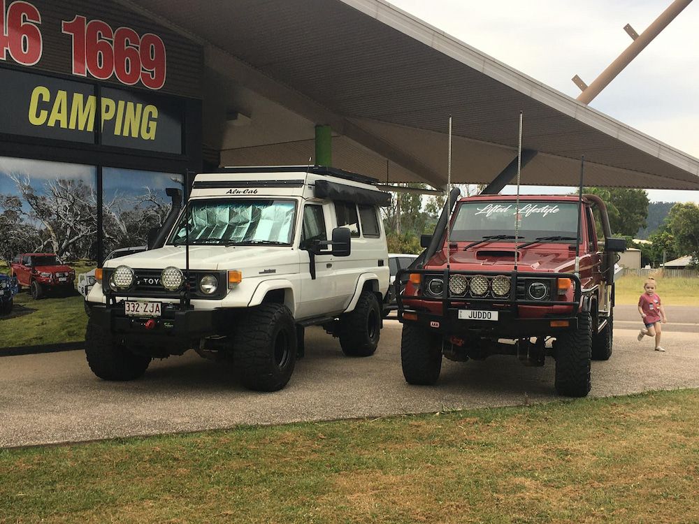 Two Trucks Are Parked in Front of a Building That Says Camping — Whitsunday 4x4 & Automotive In Airlie Beach, QLD