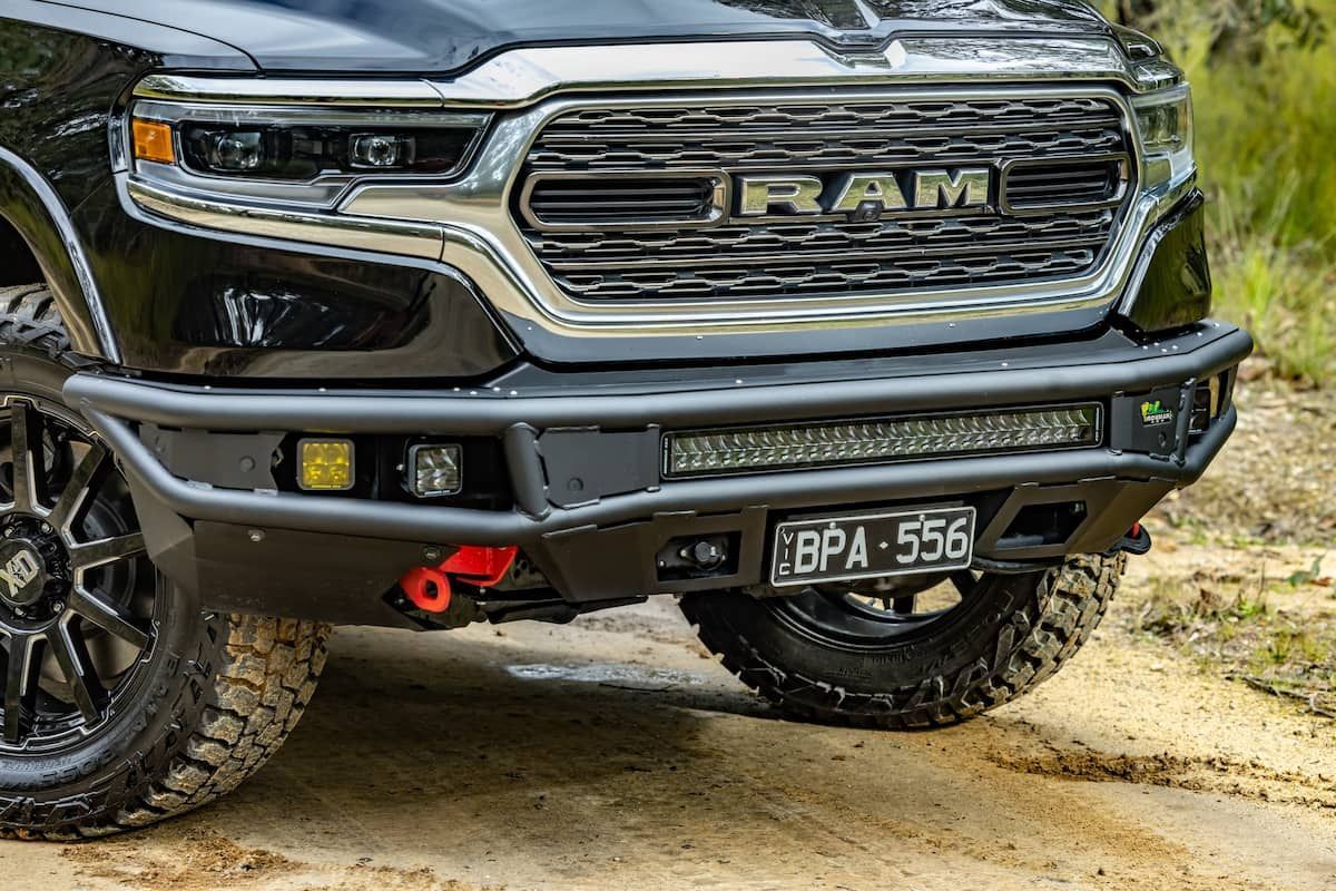 The Front Bumper of a Black Ram Truck is Sitting on a Dirt Road — Whitsunday 4x4 & Automotive In Cannonvale, QLD