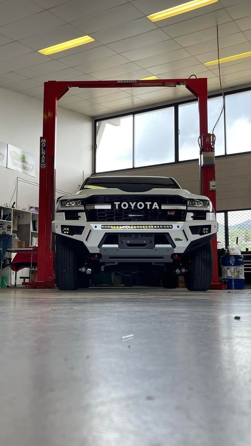 A Toyota Truck is Parked on a Lift in a Garage — Whitsunday 4x4 & Automotive In Bowen, QLD