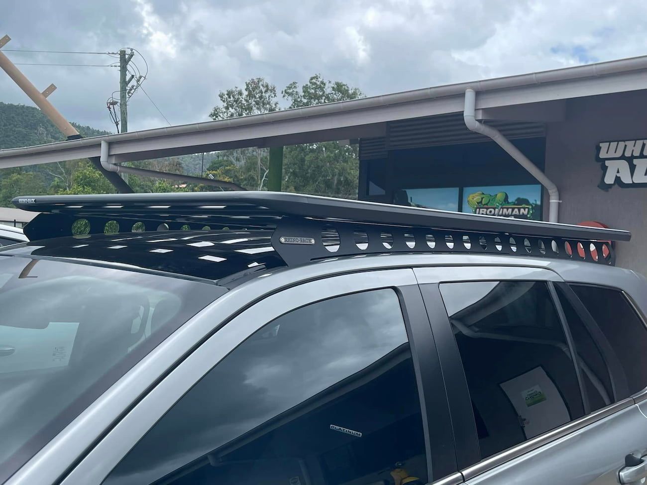 A Car With a Roof Rack on Top of It is Parked in Front of a Building — Whitsunday 4x4 & Automotive In Proserpine, QLD