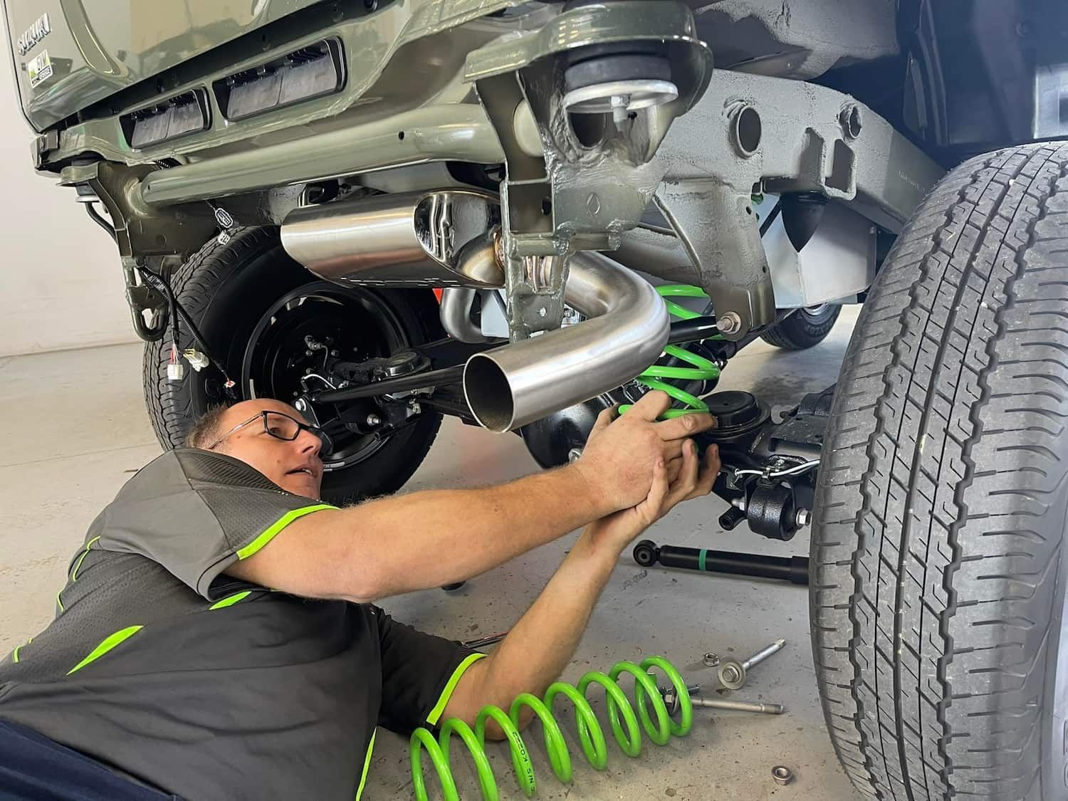 A Man is Working on the Underside of a Car — Whitsunday 4x4 & Automotive In Airlie Beach, QLD