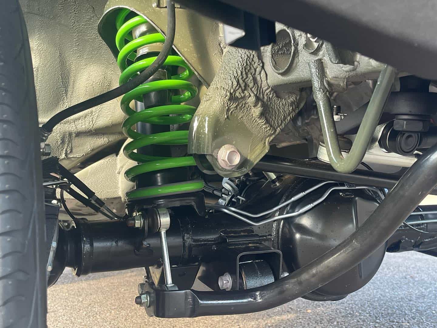 A Close Up of the Underside of a Car With a Green Shock Absorber — Whitsunday 4x4 & Automotive In Cannonvale, QLD