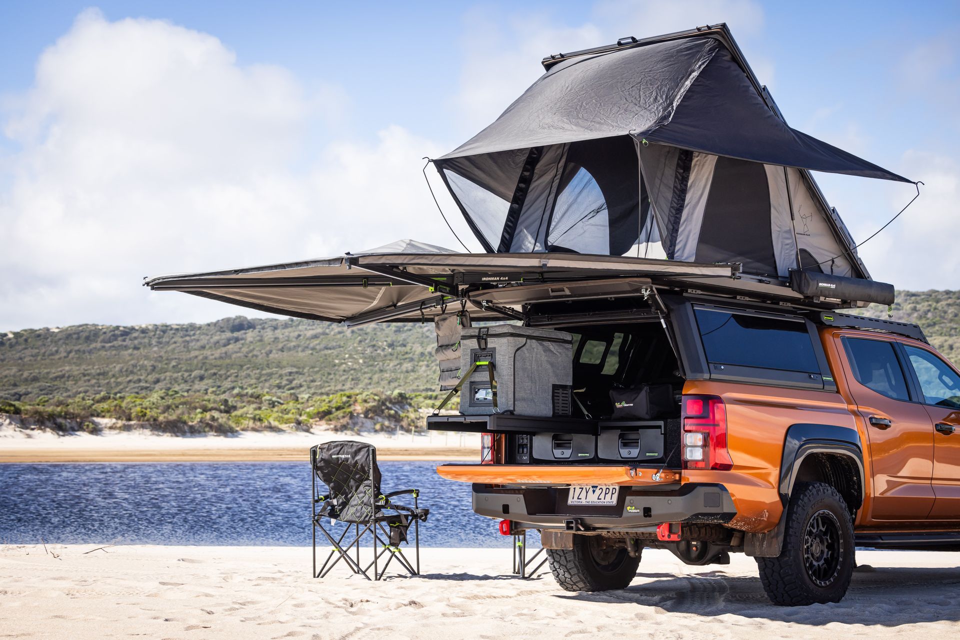 A Truck with A Tent on Top of it is Parked On the Beach - Whitsunday 4x4 & Automotive In Cannonvale, QLD