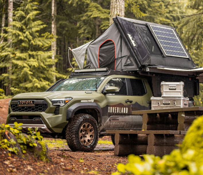 A Car with a Tent on Top of it in the Woods - Whitsunday 4x4 & Automotive In Cannonvale, QLD