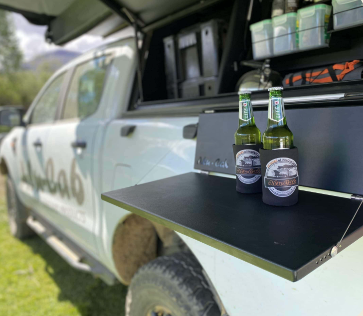 Two Bottles of Beer are Sitting on a Shelf in the Back of a Truck - Whitsunday 4x4 & Automotive In Cannonvale, QLD