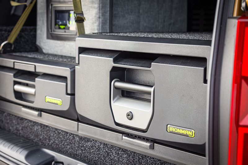 A red truck with a bunch of drawers in the back.