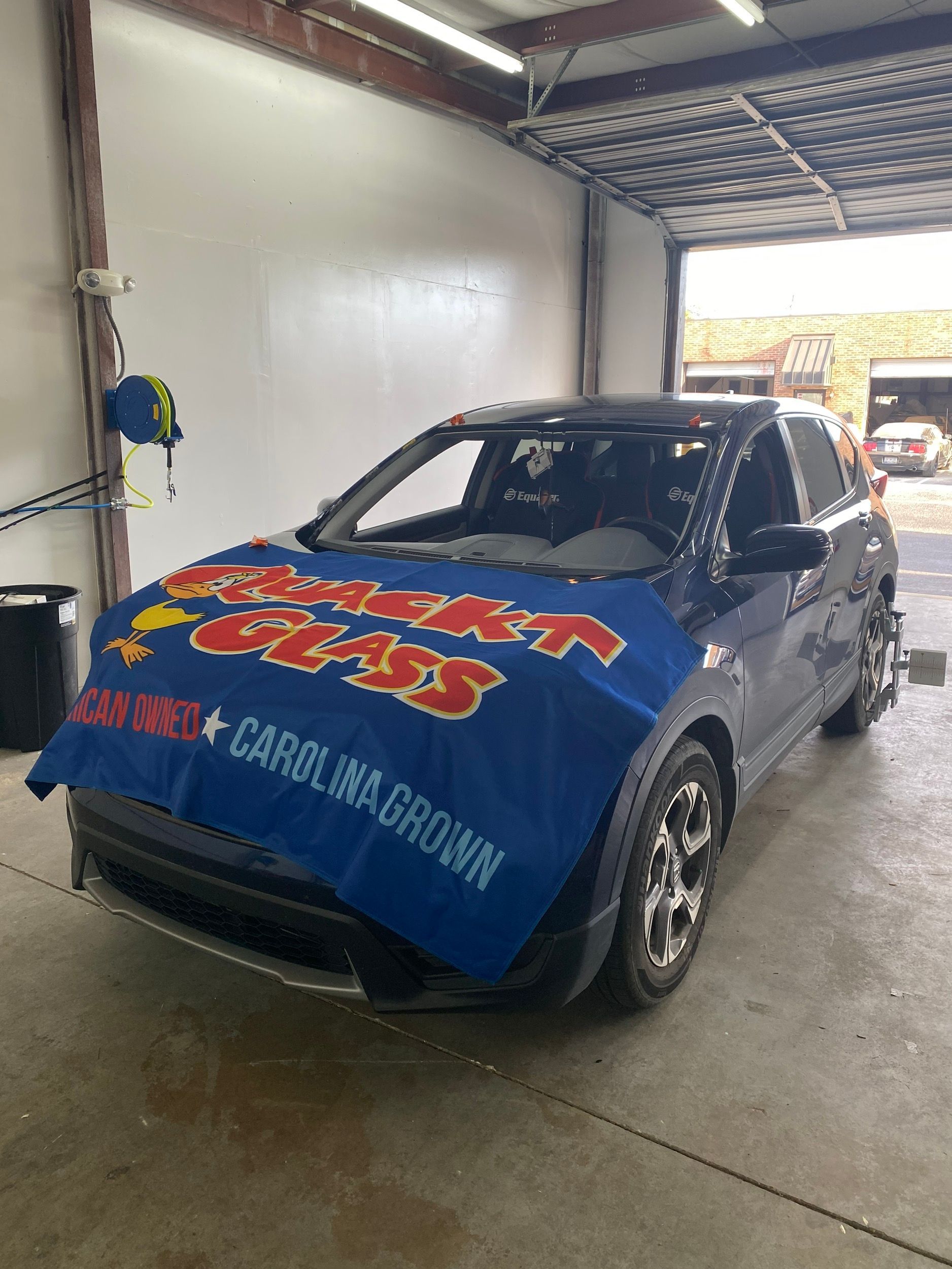 Dark blue SUV with windshield covered by a blue banner that reads 