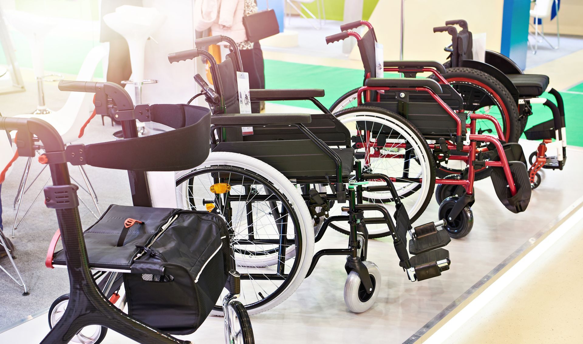 A row of various wheelchairs and a walker displayed indoors.