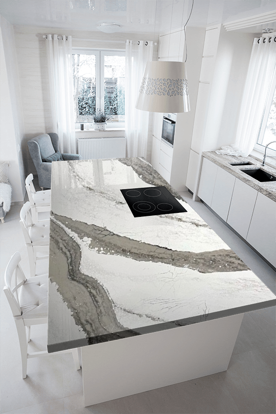 A kitchen with a large marble counter top and white cabinets.
