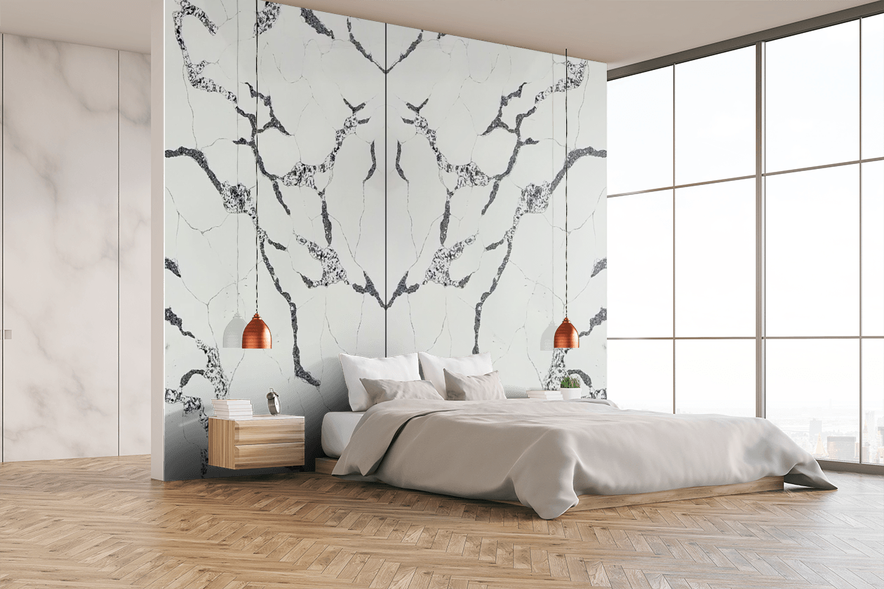 A bedroom with a large bed and a marble wall.