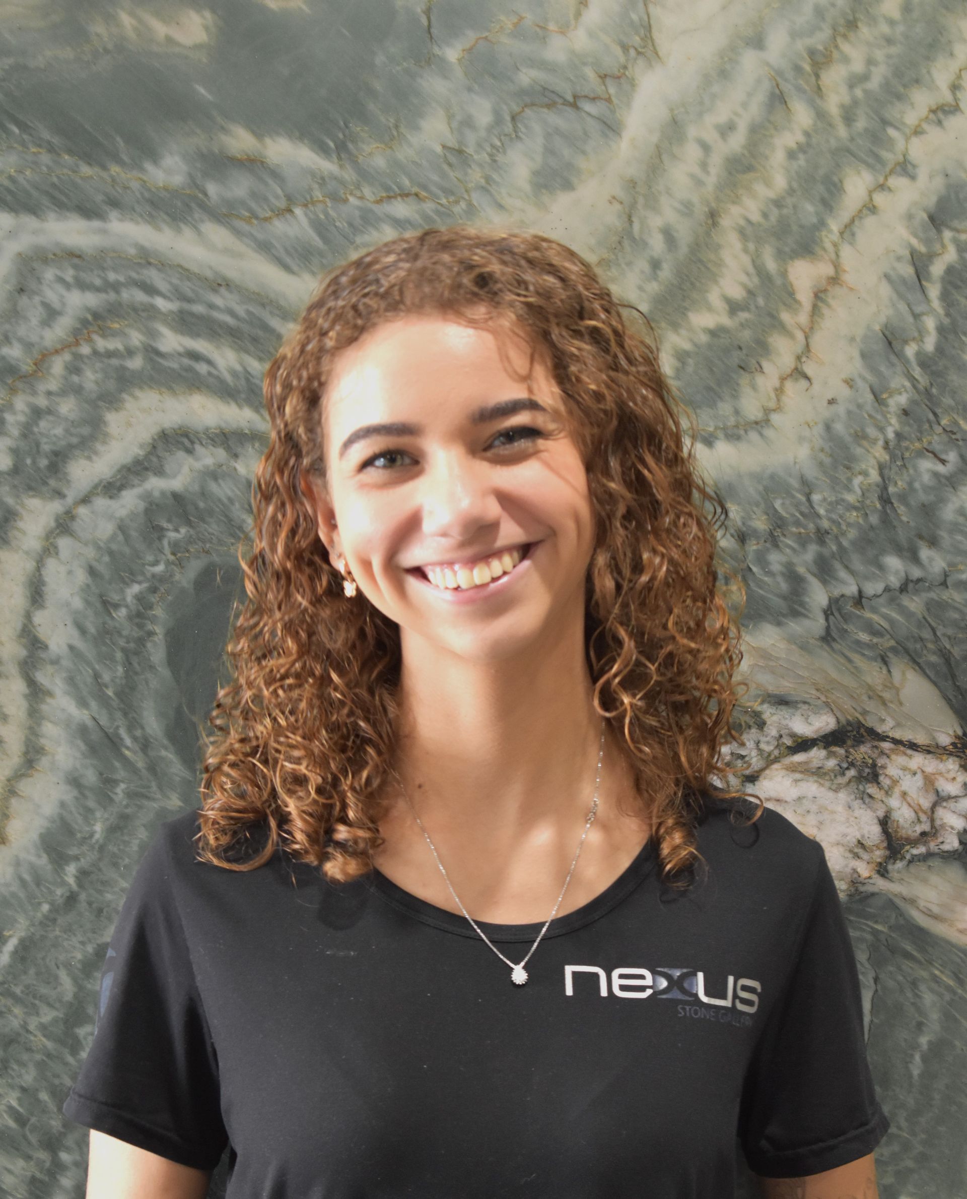 A woman wearing a black shirt with the word nexus on it