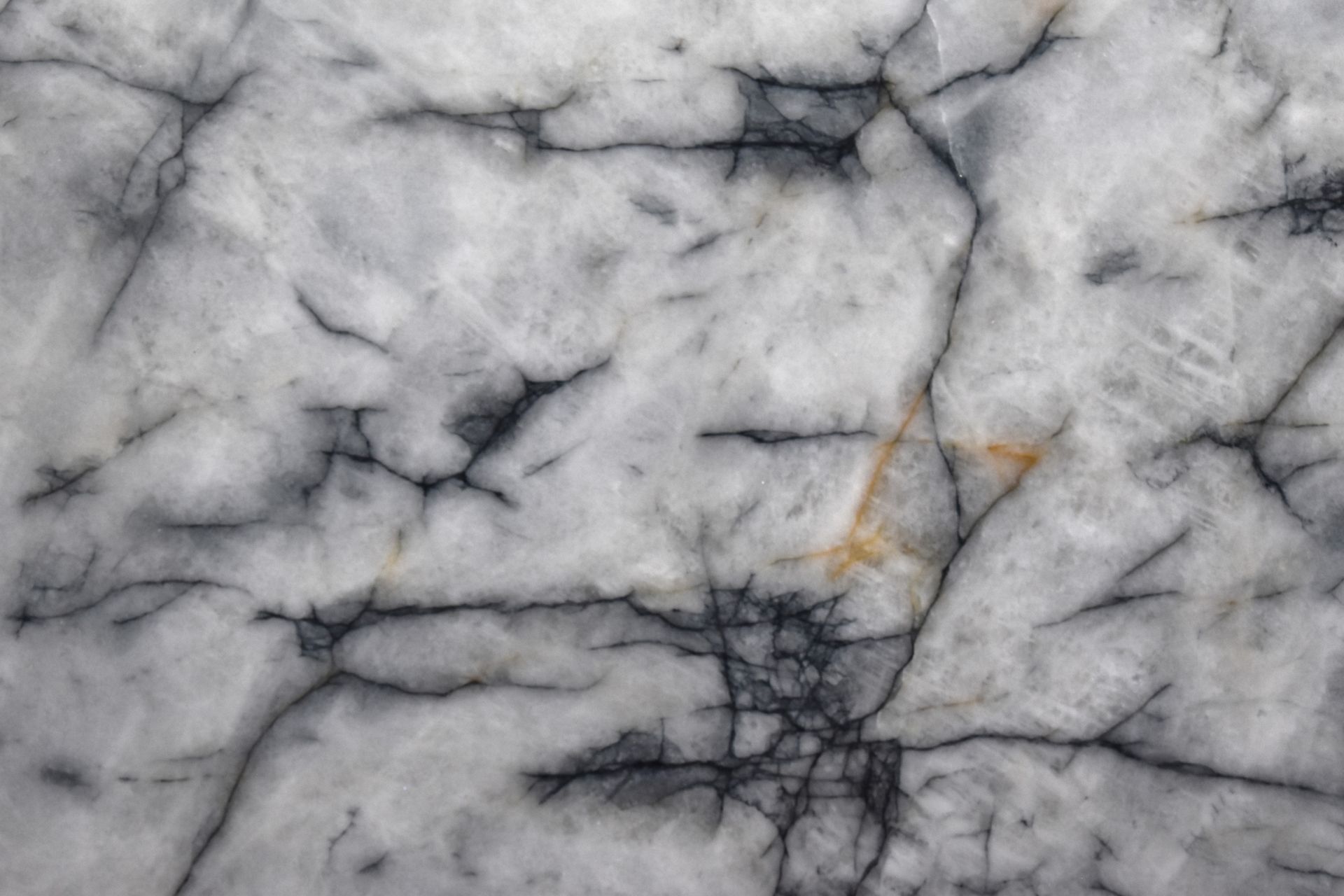 A close up of a white marble texture with black veins.