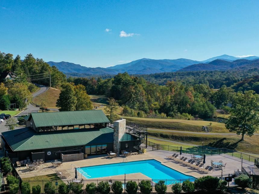 An aerial view of a swimming pool with mountains in the background.