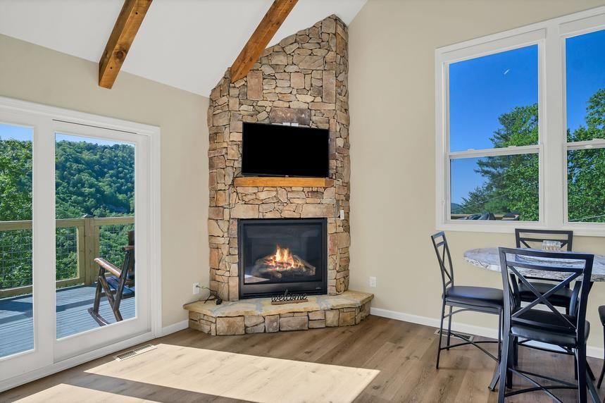 A living room with a fireplace and a flat screen tv.