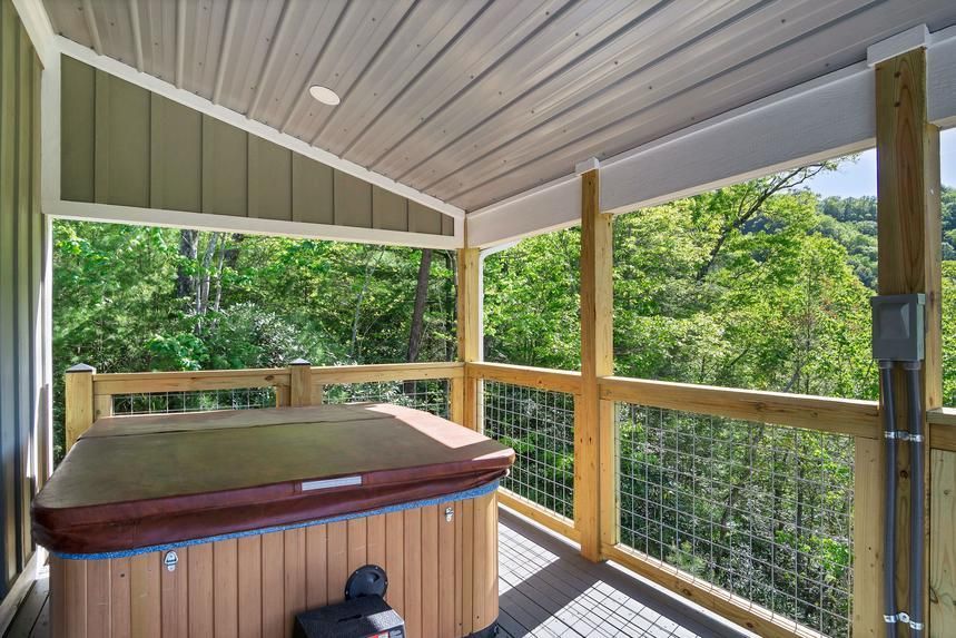 There is a hot tub on the porch of a house.