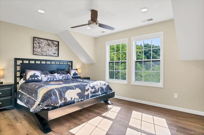 A bedroom with a king size bed and a ceiling fan.