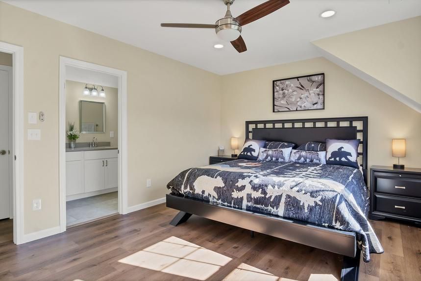 A bedroom with a king size bed and a ceiling fan.