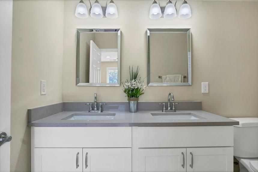A bathroom with two sinks and two mirrors.