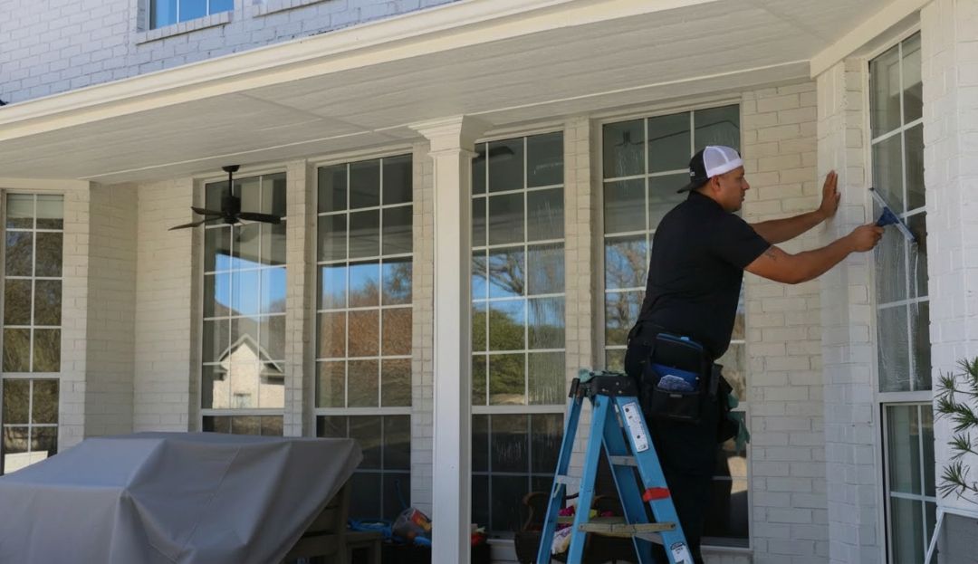Amazing Finish Windows tech cleaning a large exterior window on a Dallas home in mild fall weather.