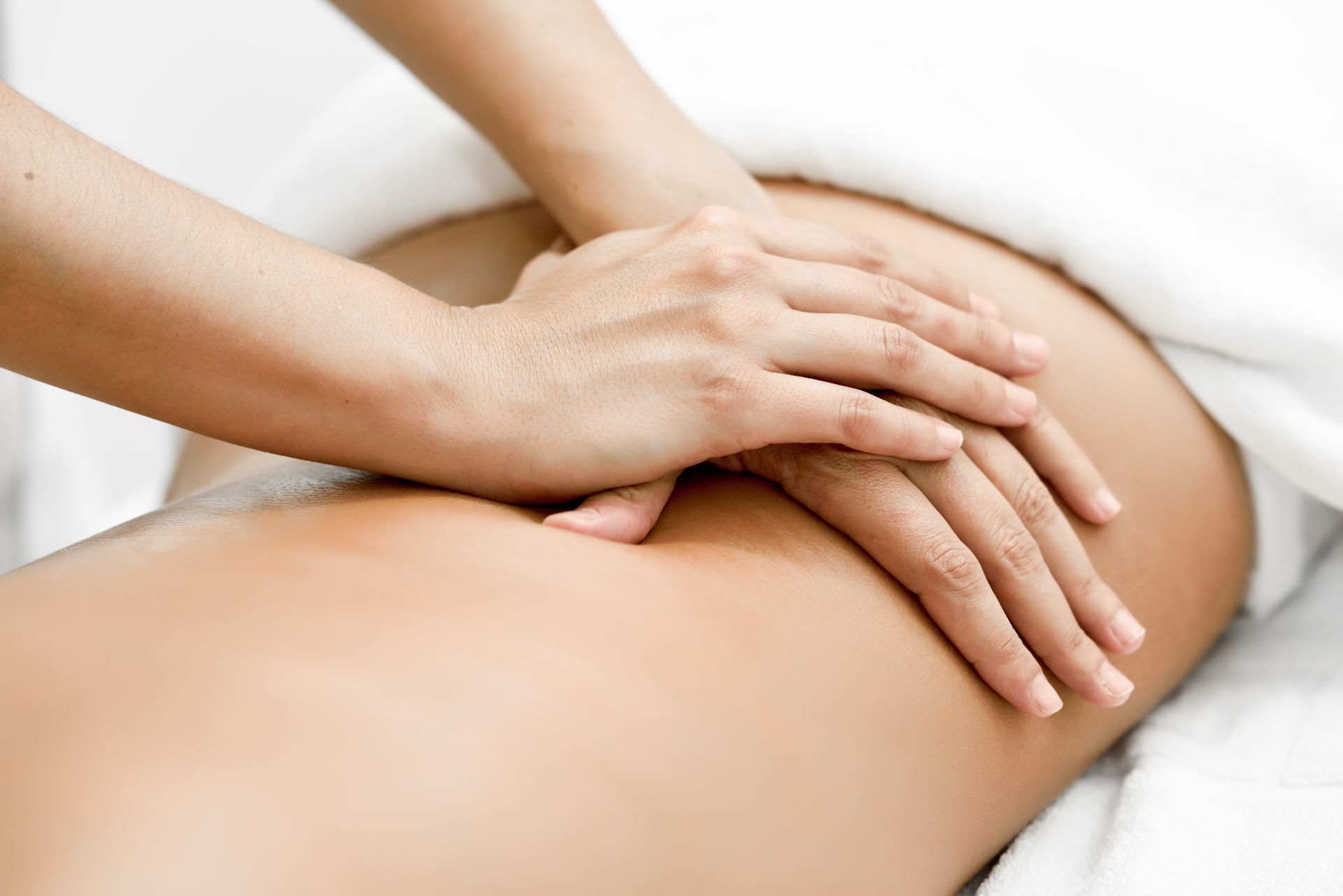 A woman is getting a massage with her hands on her back.