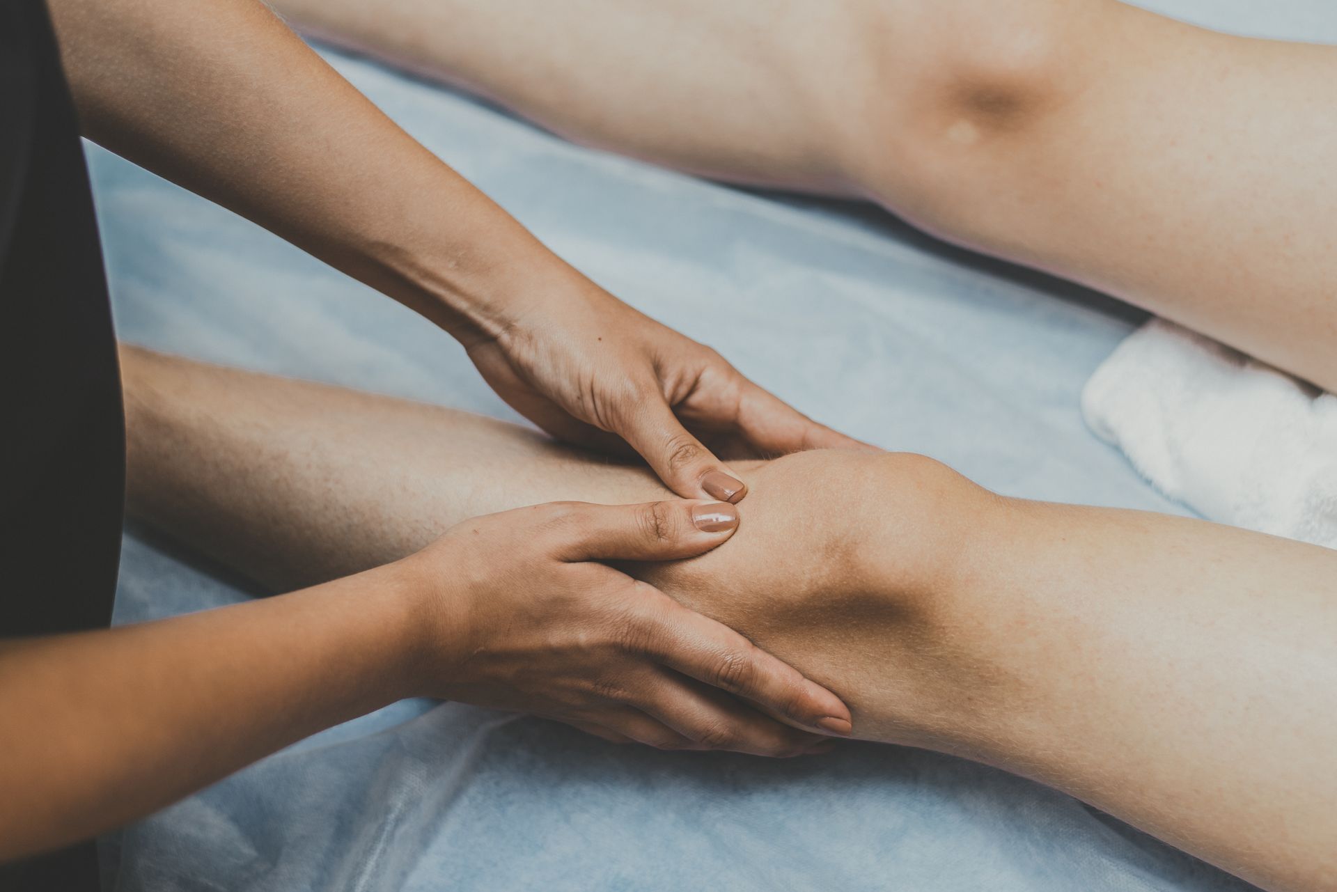 A woman is getting a massage on her leg in a spa.