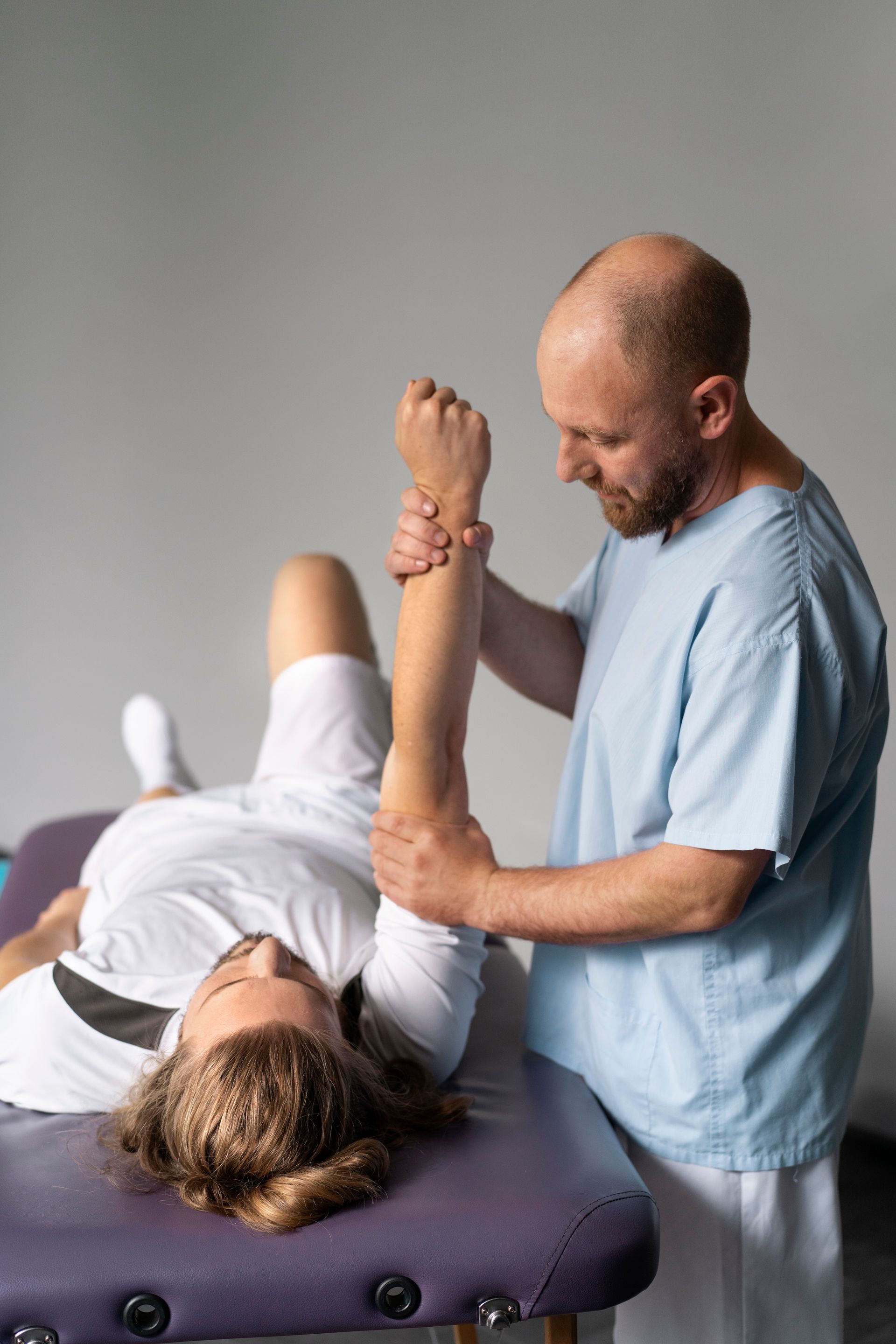 physio therapist stretching woman's arm