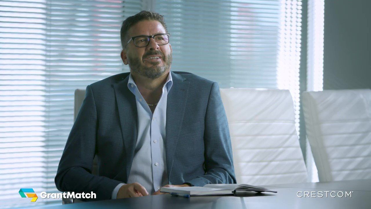 A man in a suit and glasses is sitting at a table.