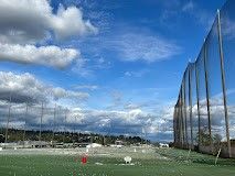 A golf course with a blue sky and clouds in the background.