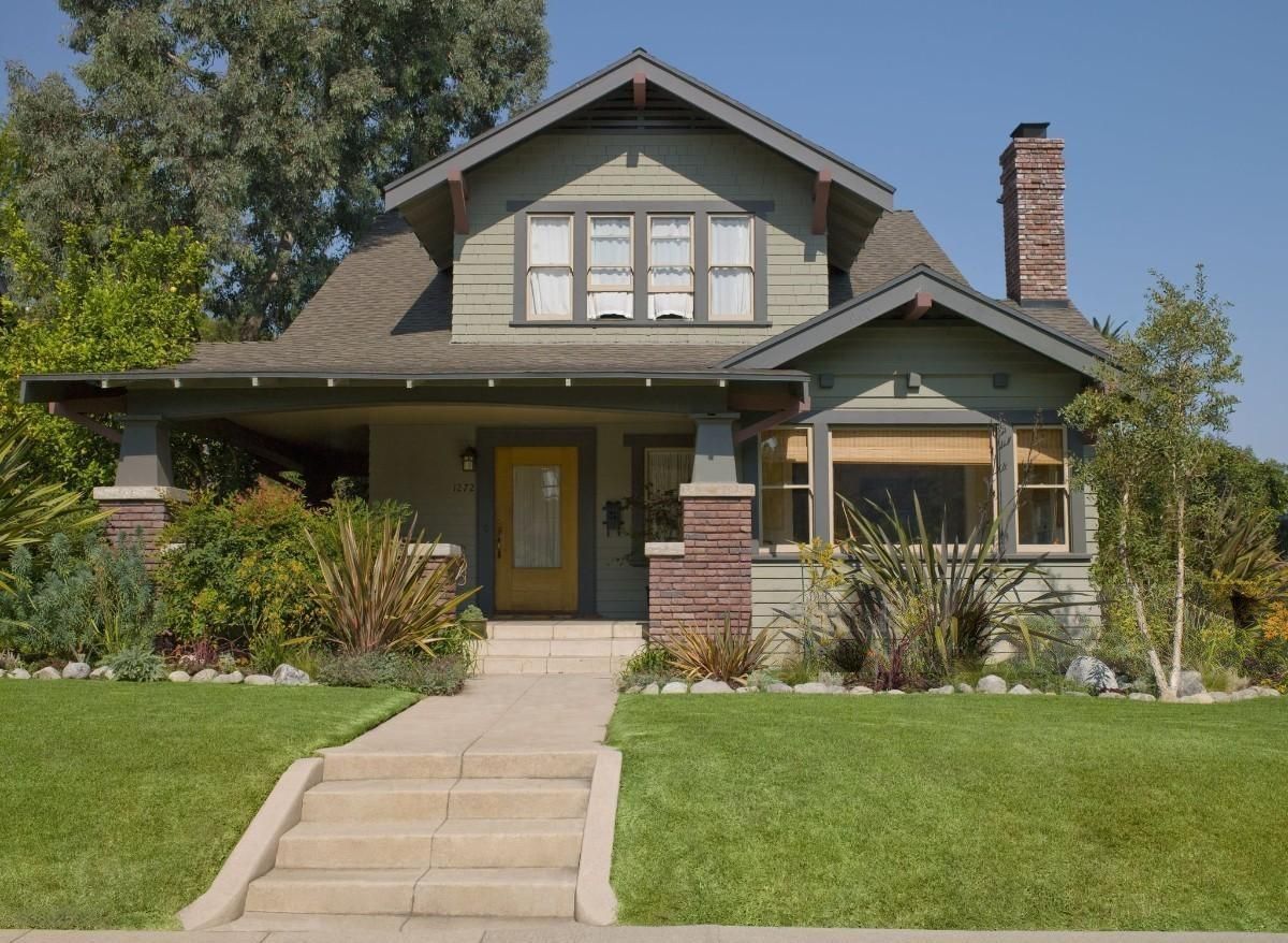 a house with a yellow door and a brick chimney