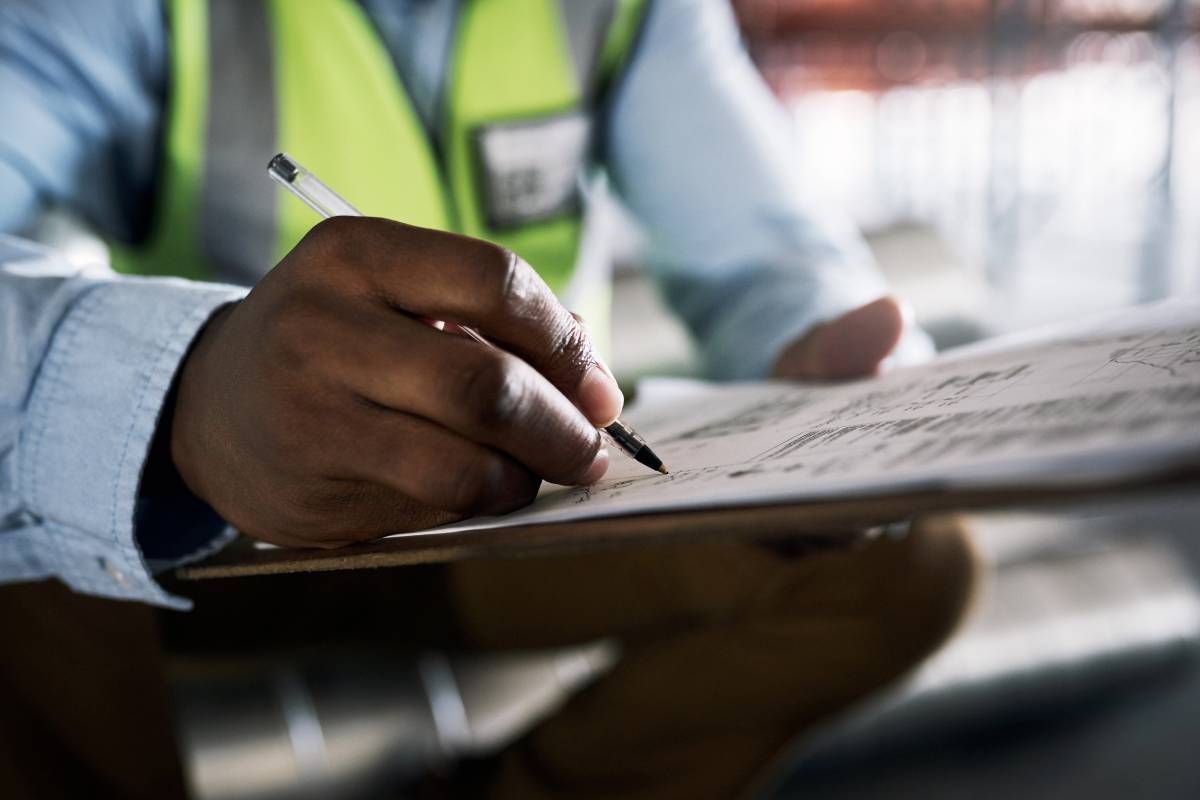 A radon tester writes notes for a radon mitigation system near Lexington, KY