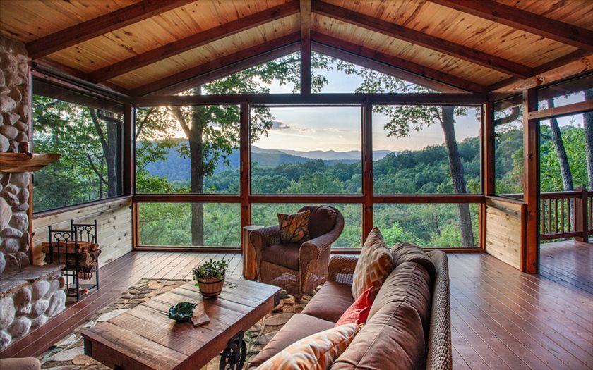 A living room with a couch and chairs and a view of the mountains