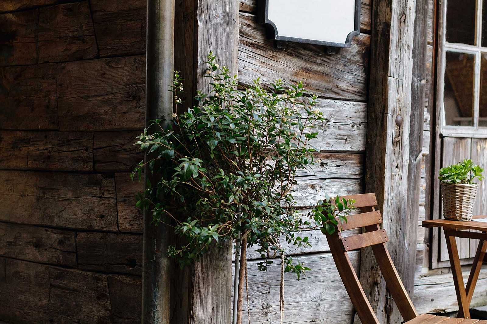 A wooden chair is sitting in front of a wooden wall.
