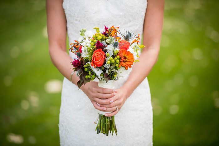 A woman in a white dress is holding a bouquet of flowers