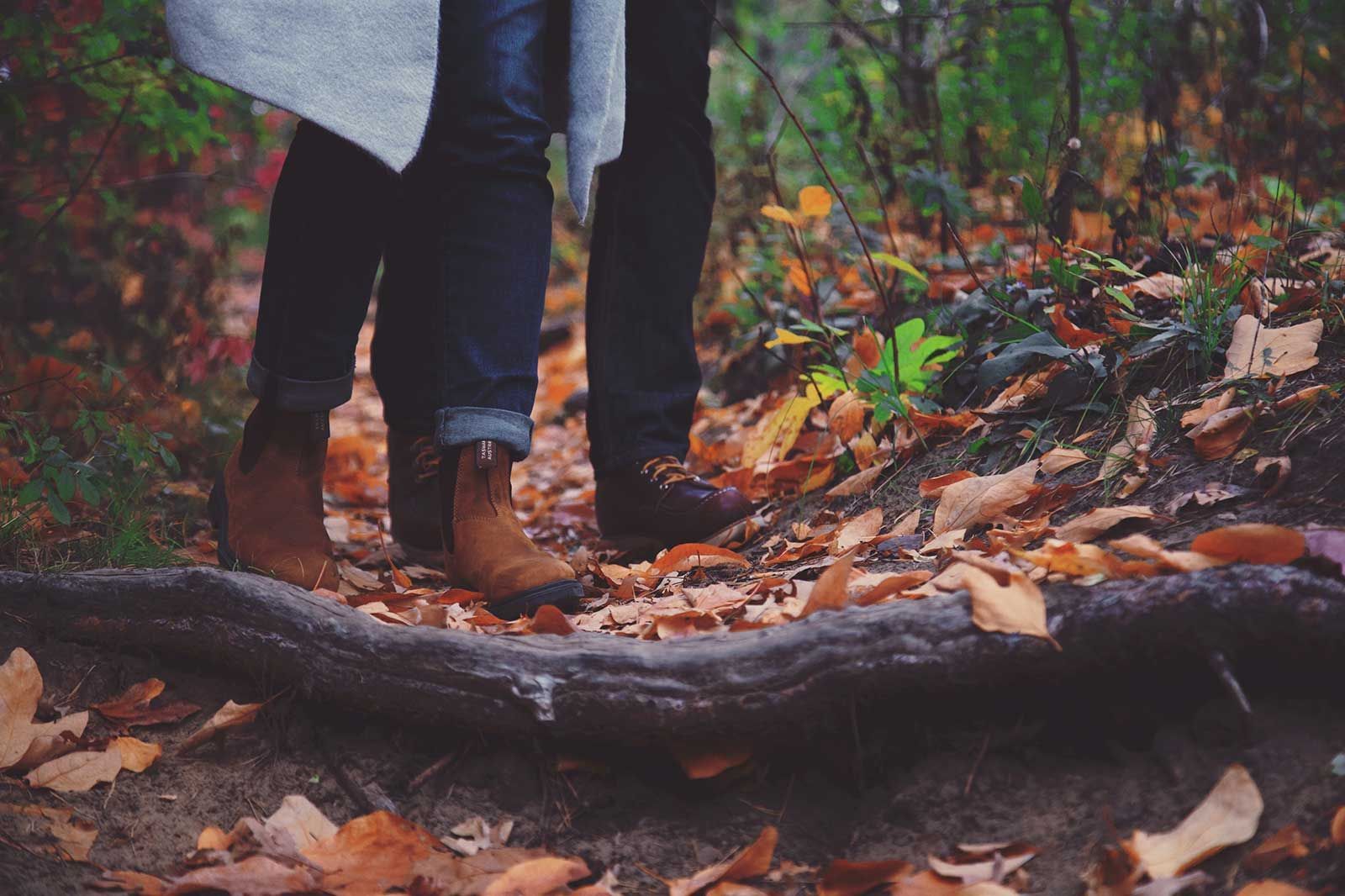 A couple standing next to each other on a path in the woods