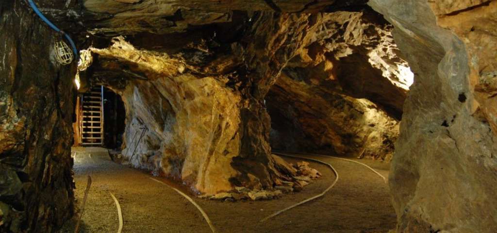 A tunnel in a cave with a ladder in the background