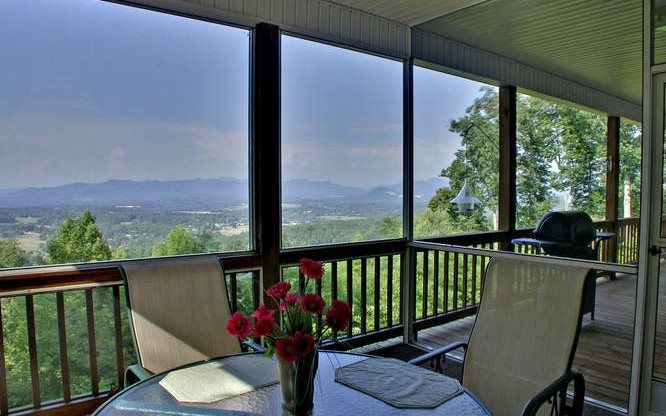 A screened in porch with a view of the mountains