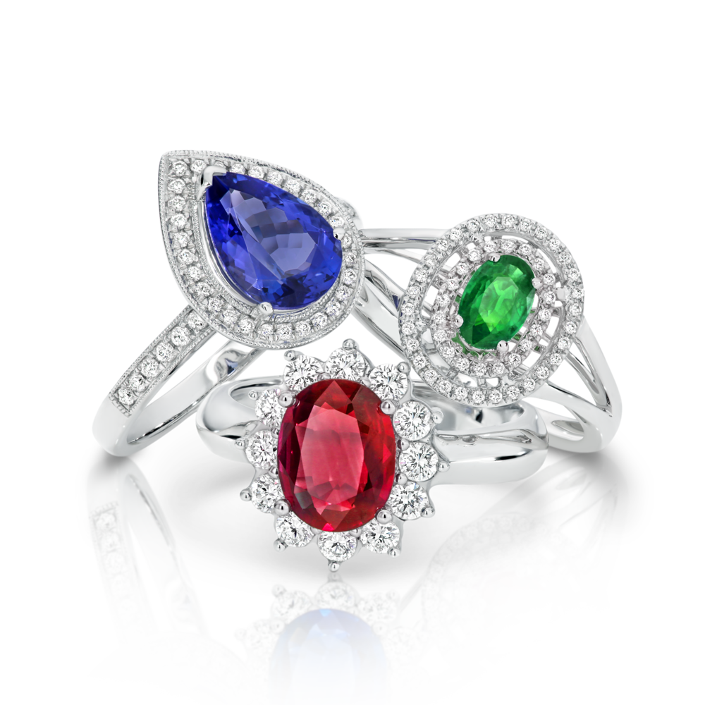 Three rings with different colored stones are stacked on top of each other.