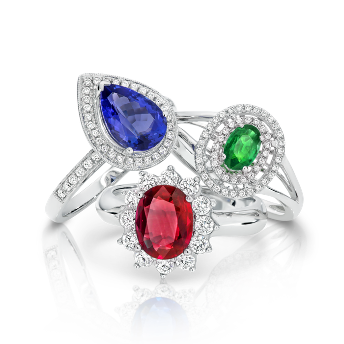 Three rings with different colored stones are stacked on top of each other.