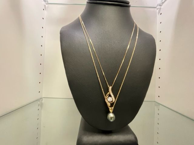 Two necklaces are on display on a mannequin