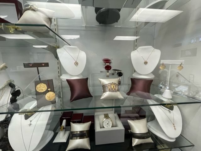 A glass display case filled with jewelry and watches