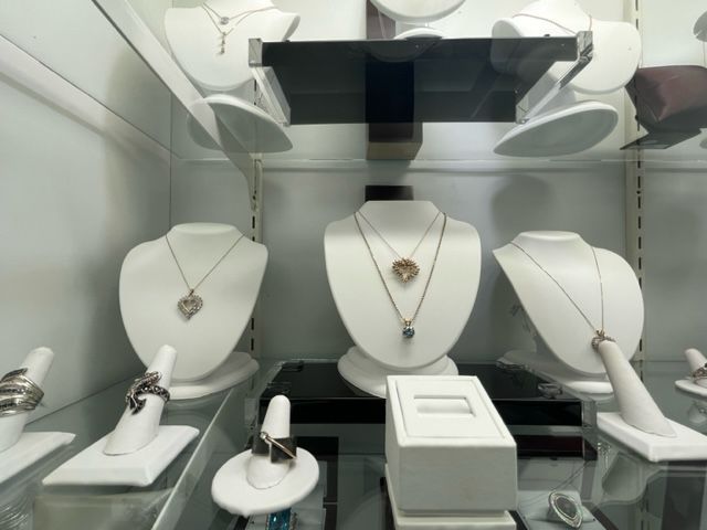 A display of necklaces and rings on mannequins in a store
