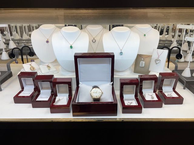 A display of jewelry including a watch in a wooden box