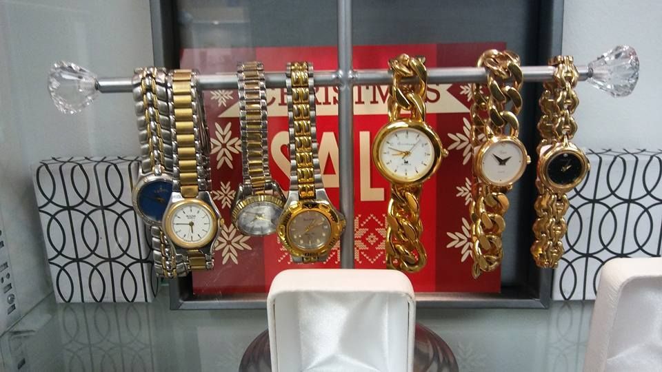 Watches displayed on a rack in front of a red