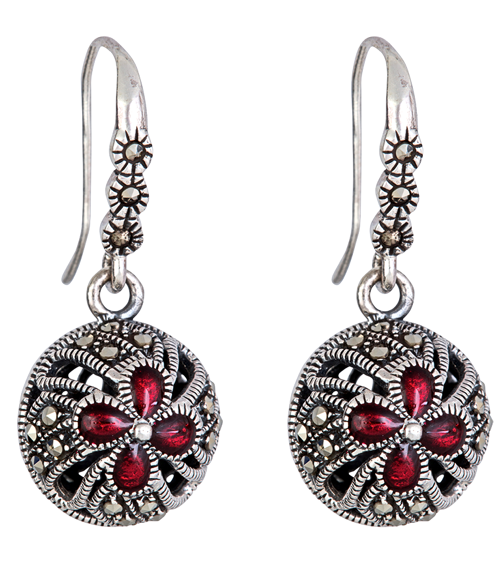 A pair of silver earrings with red stones on them