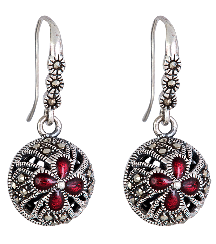 A pair of silver earrings with red stones on them