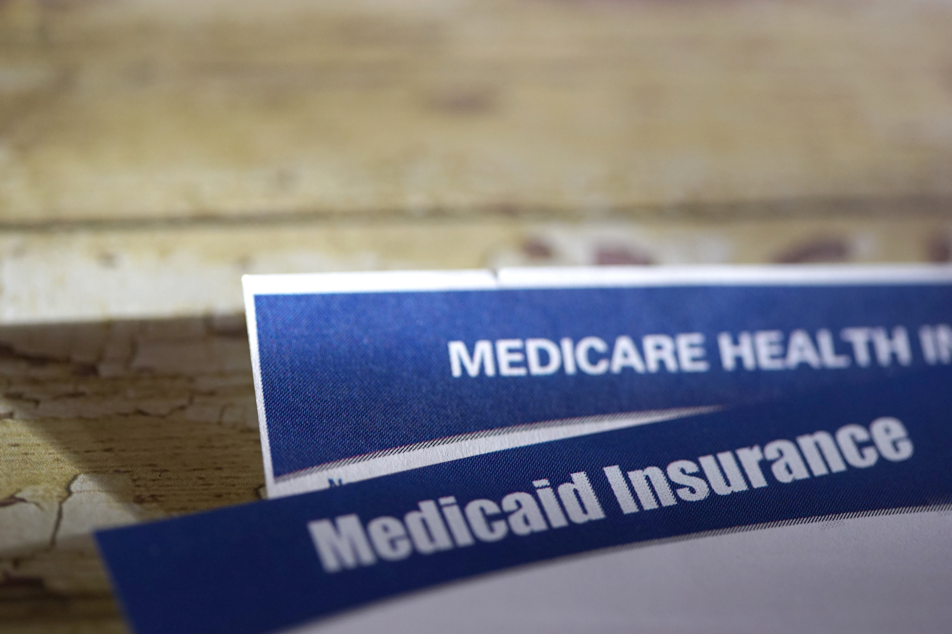 A close up of a medicare health insurance card on a wooden table.