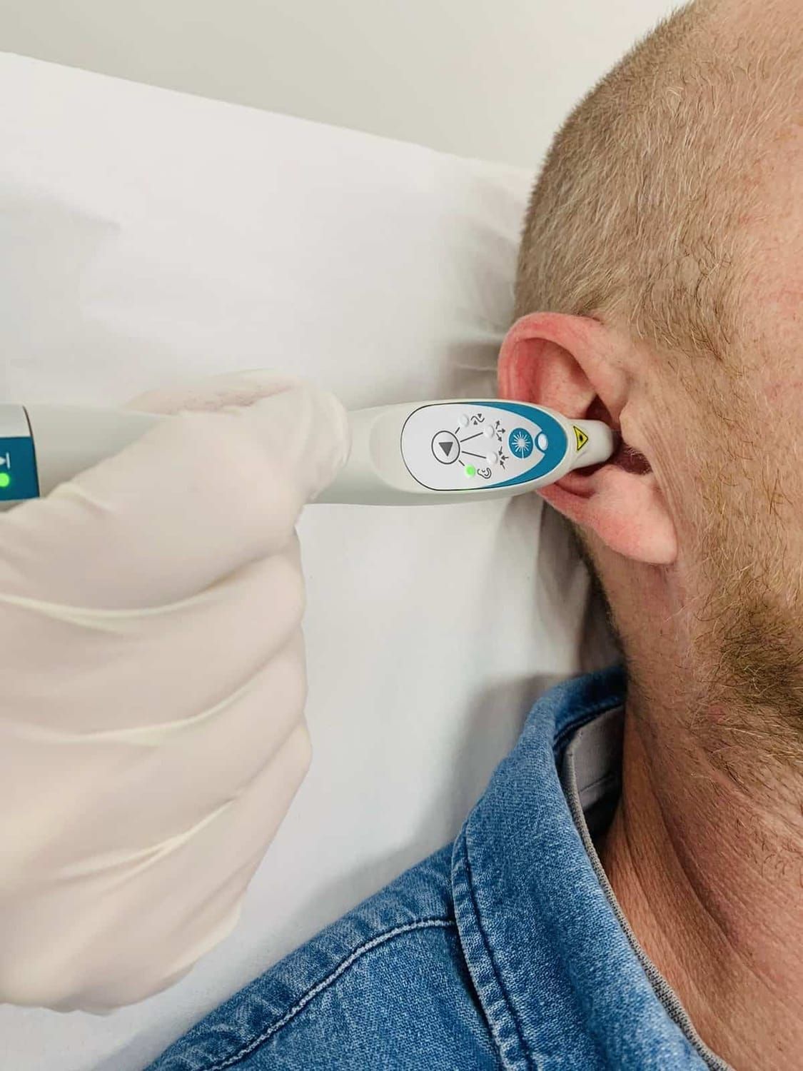 Un homme se fait prendre sa température avec un thermomètre dans l'oreille.