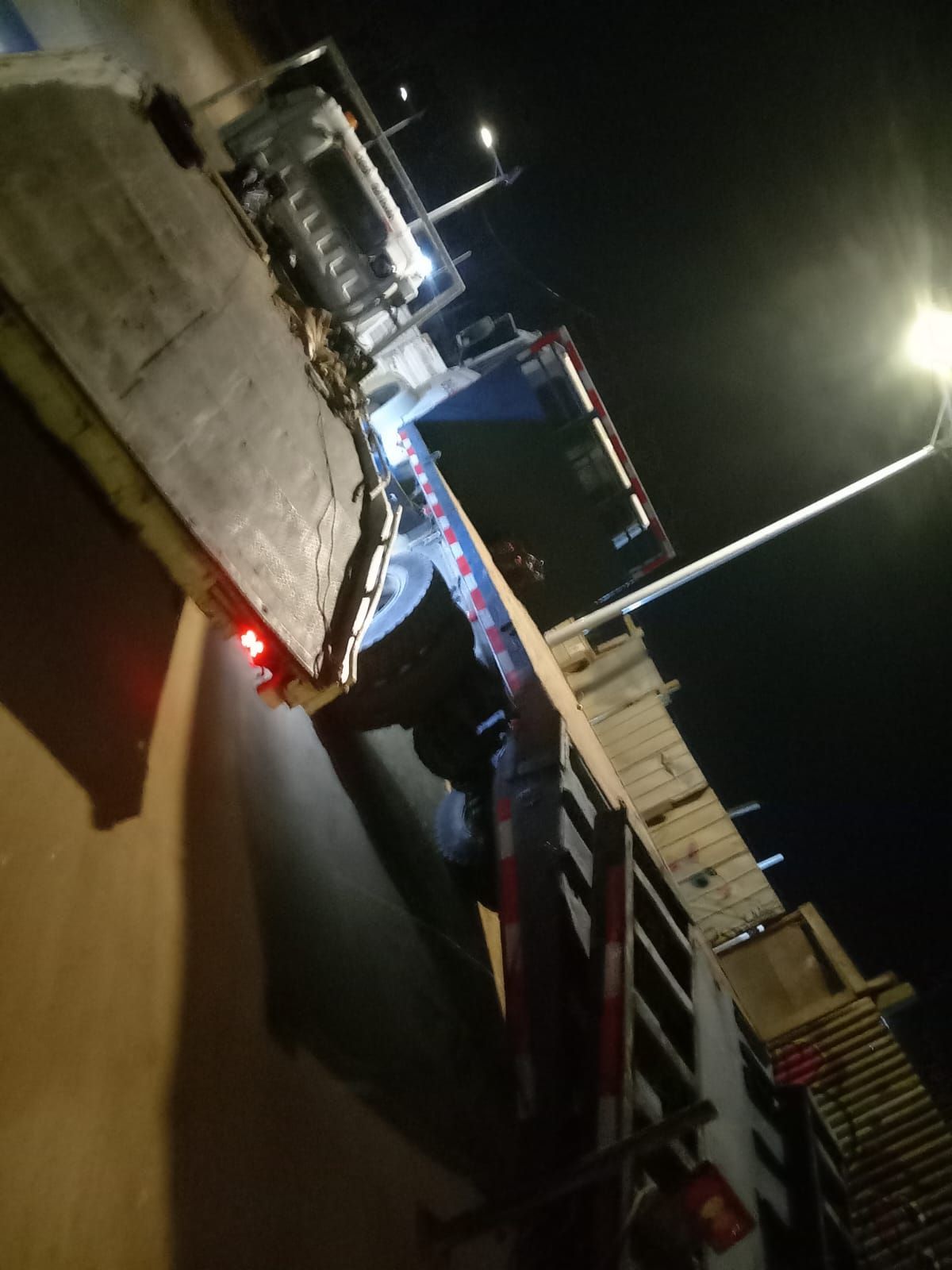 Un camión está estacionado al costado de la carretera por la noche.