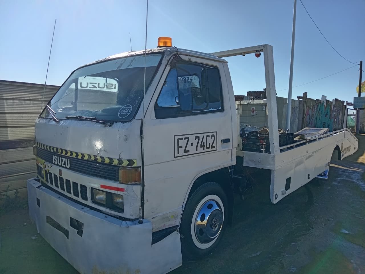 Una grúa blanca está estacionada en un estacionamiento.